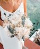 Bouquet de mariée Gemma_Rosacadaques_Fleurs séchées 2 femme blonde en robe de mariée qui tient un bouquet de fleurs séchées rosa cadaqués hortensia eucalyptus