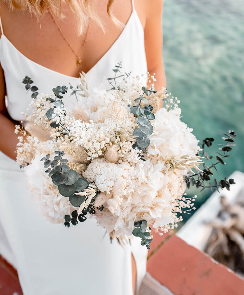 Bouquet de mariée Gemma_Rosacadaques_Fleurs séchées 2 femme blonde en robe de mariée qui tient un bouquet de fleurs séchées rosa cadaqués hortensia eucalyptus