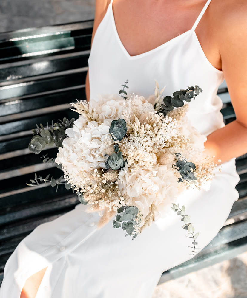 femme blonde en robe de mariée qui tient un bouquet de fleurs séchées rosa cadaqués hortensia eucalyptus