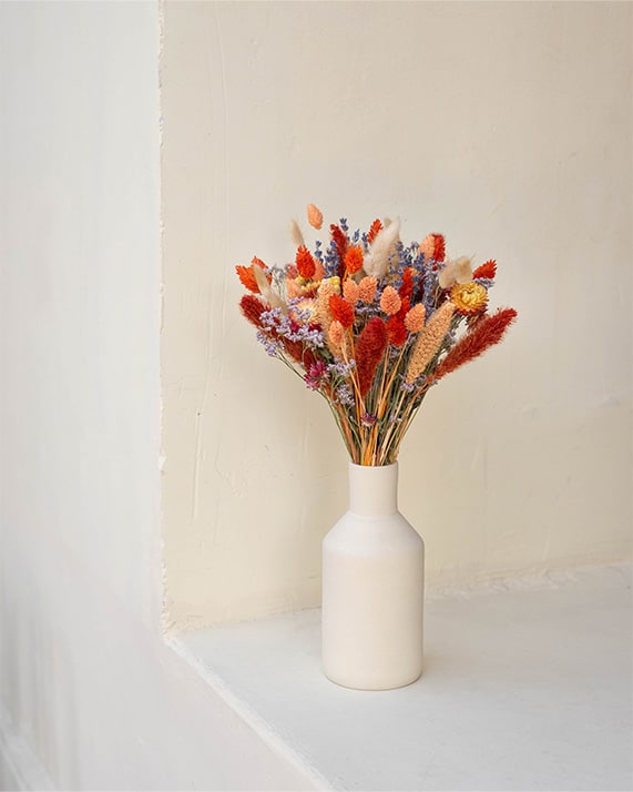 Bouquet rouge orangé et vase beige